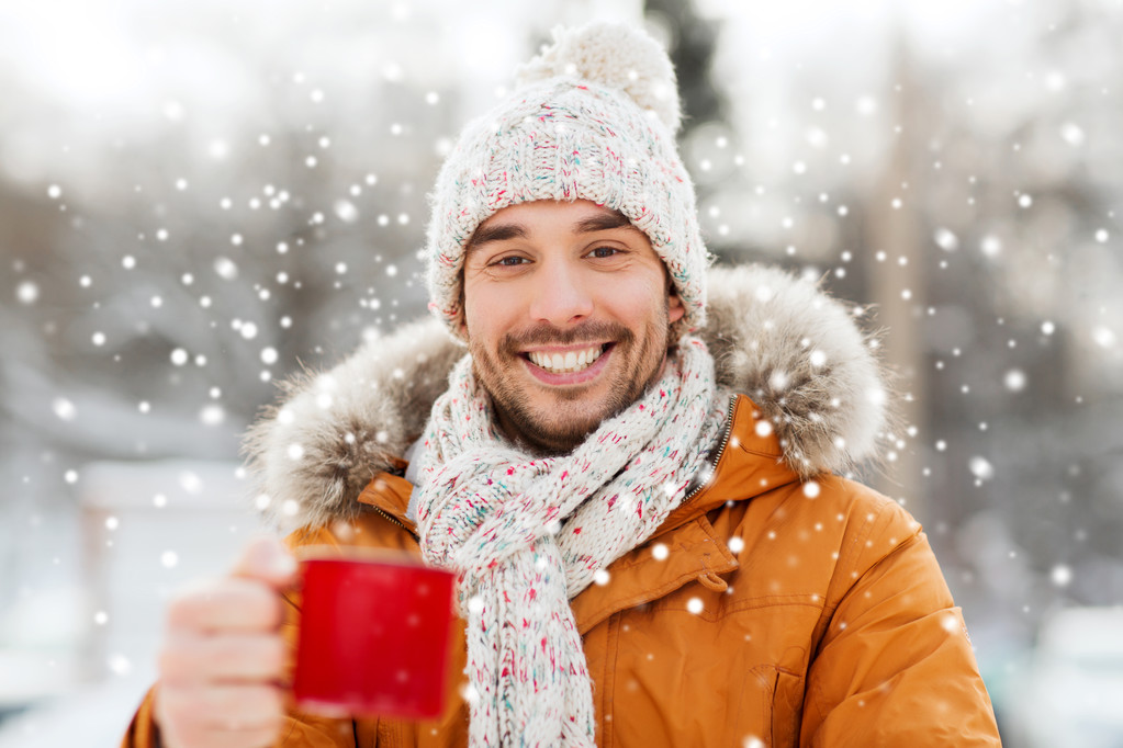 gelukkig man met thee kopje buiten in de winter - Foto, afbeelding