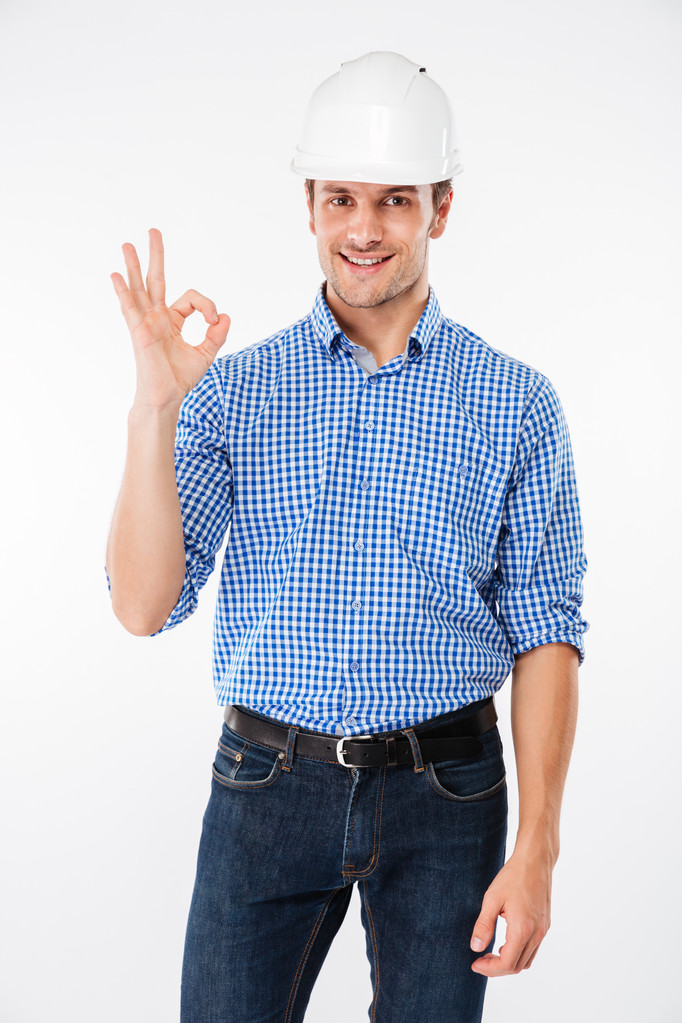 Sorrindo jovem construtor em chapéu duro mostrando gesto ok
 - Foto, Imagem