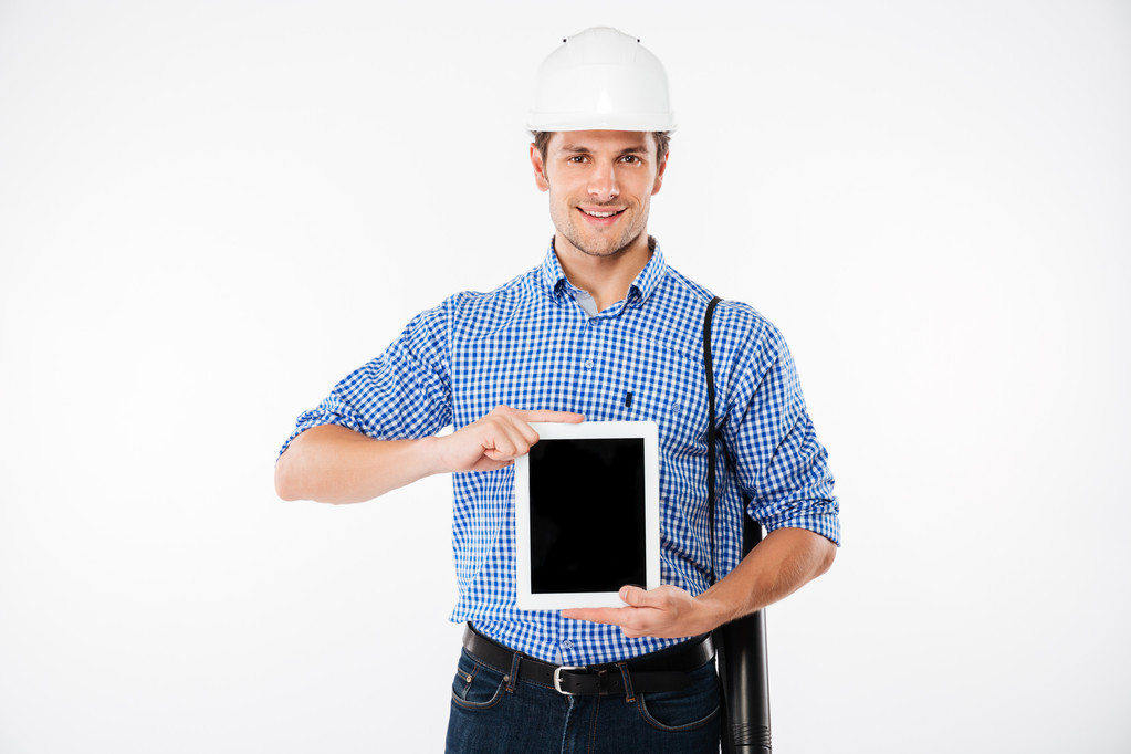 Vrolijke man bouwer in harde hoed weergegeven: leeg scherm tablet - Foto, afbeelding