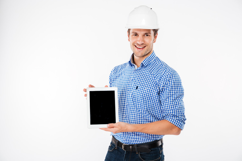 Hombre feliz arquitecto en el edificio casco celebración de tableta de pantalla en blanco
 - Foto, Imagen