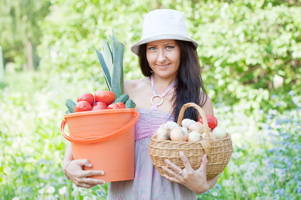 Gelukkige vrouw houdt groenten oogst - Foto, afbeelding