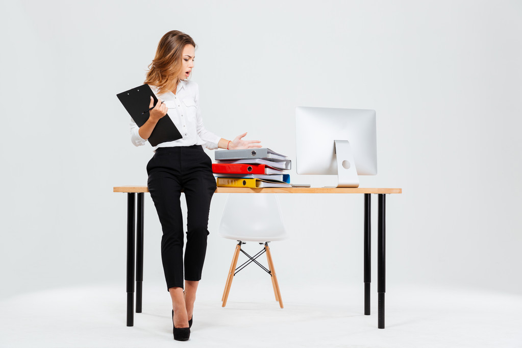 Frustrada empresaria estresada de pie en el escritorio de la oficina
 - Foto, Imagen
