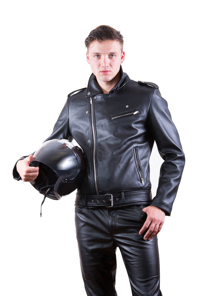 Siyah deri ceket ve motosiklet kask tutarak ve kameraya bakarak pantolon giyen yakışıklı motorcu adam portresi - Fotoğraf, Görsel