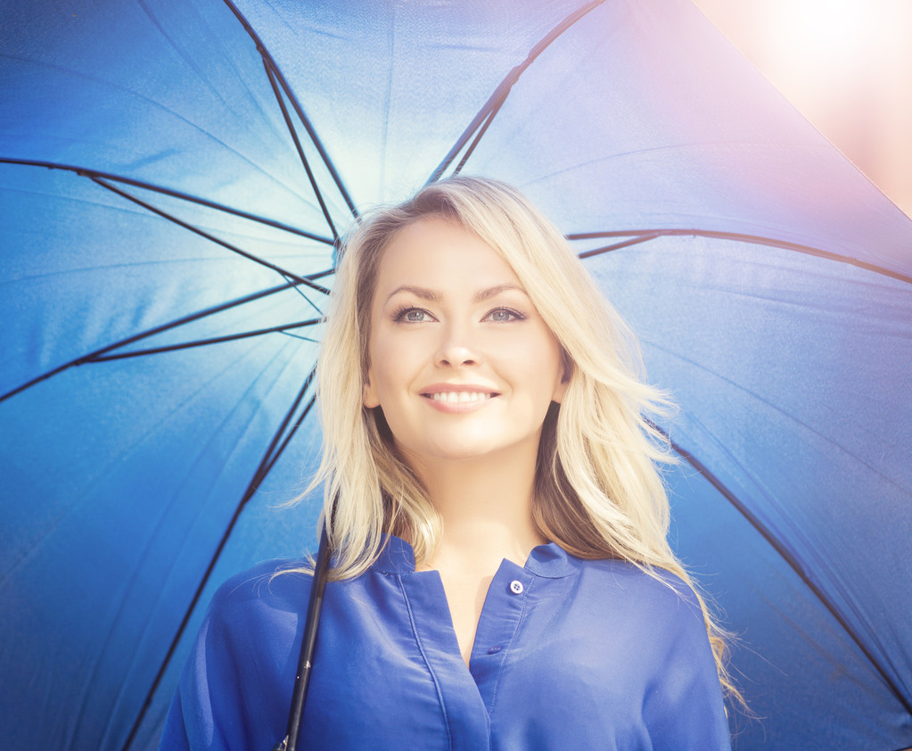 Молодая и счастливая женщина под голубым зонтиком
 - Фото, изображение