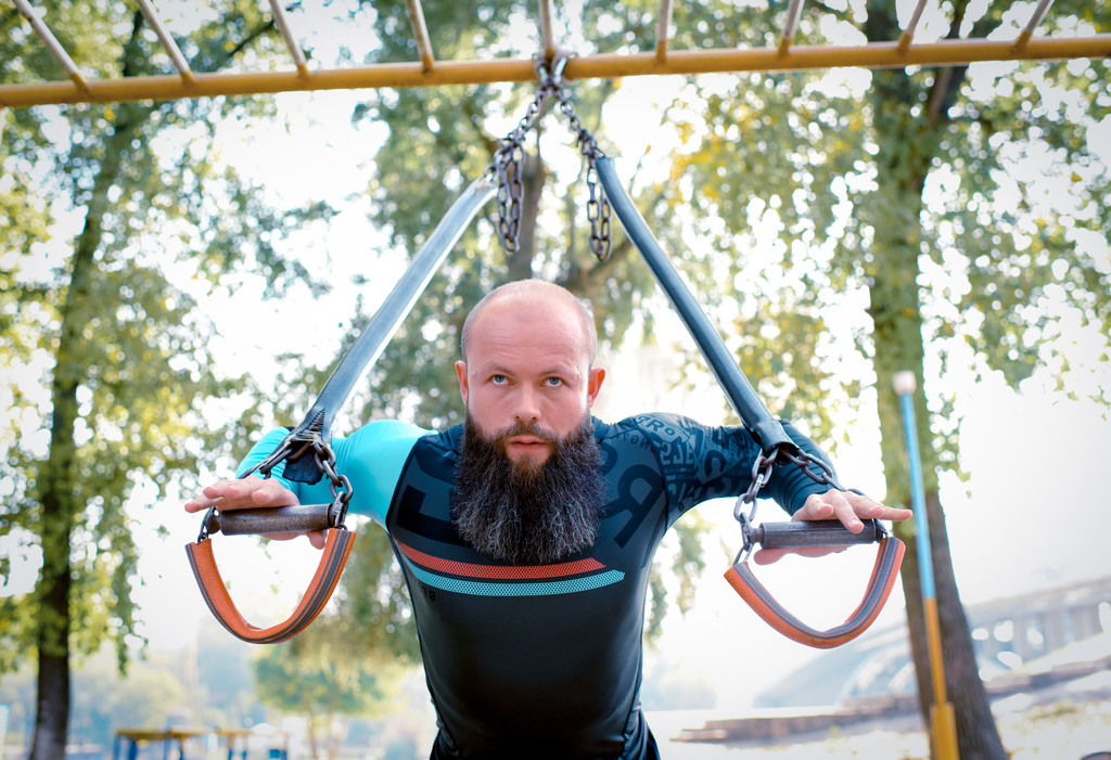 Человек тренируется с ремнями в парке
 - Фото, изображение