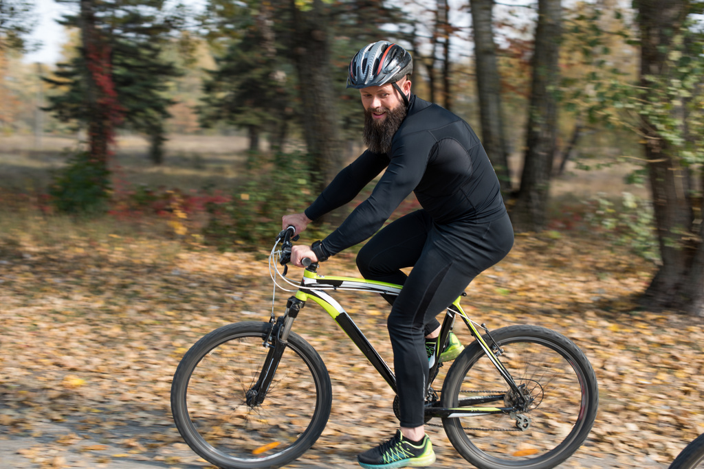 Бородатий чоловік їде на велосипеді в парку
 - Фото, зображення