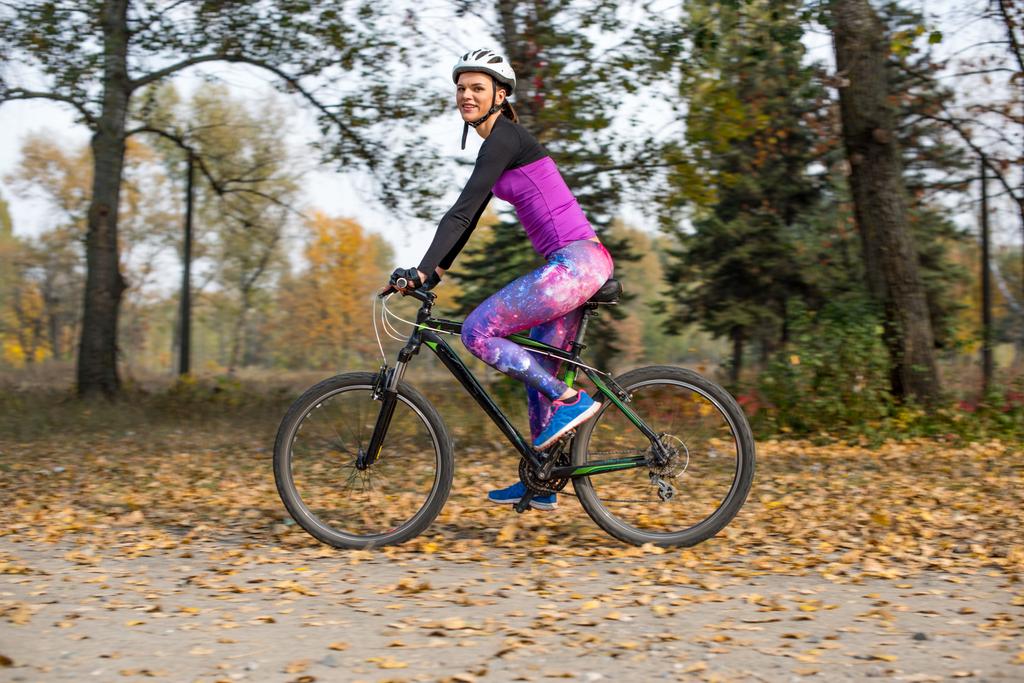 vrouw fietsen in herfst park - Foto, afbeelding