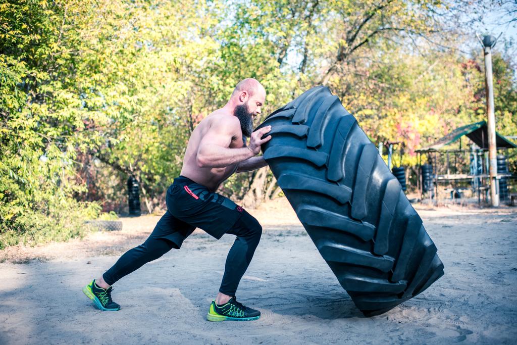 Man lifting a heavy tire  - Photo, Image