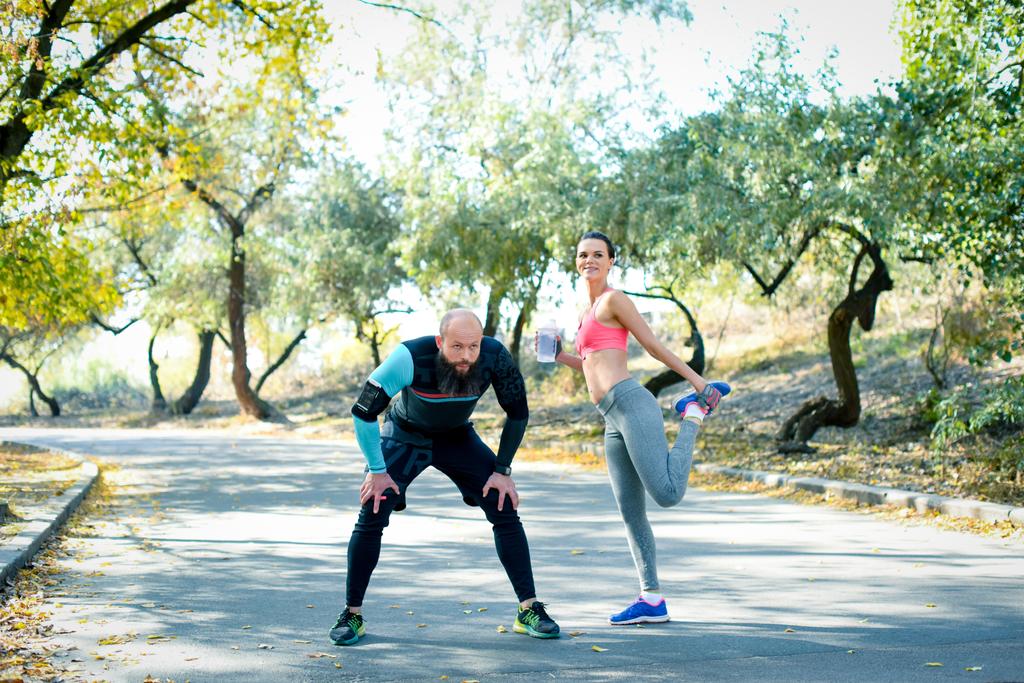 Paar dehnt Muskeln vor sportlicher Aktivität  - Foto, Bild