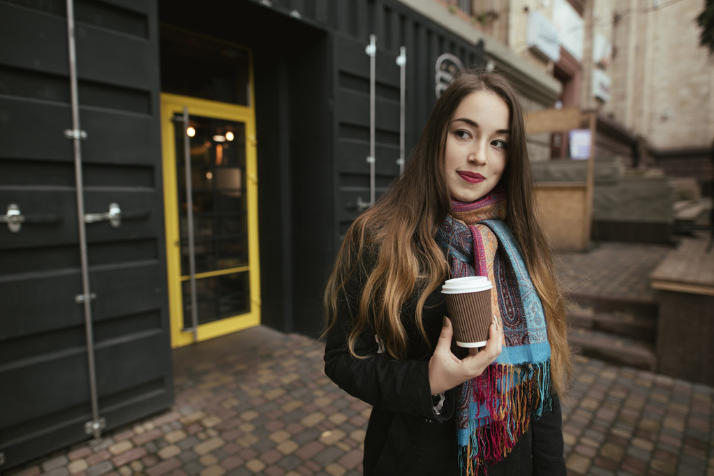 Client féminin sortant du café avec une tasse de café
 - Photo, image