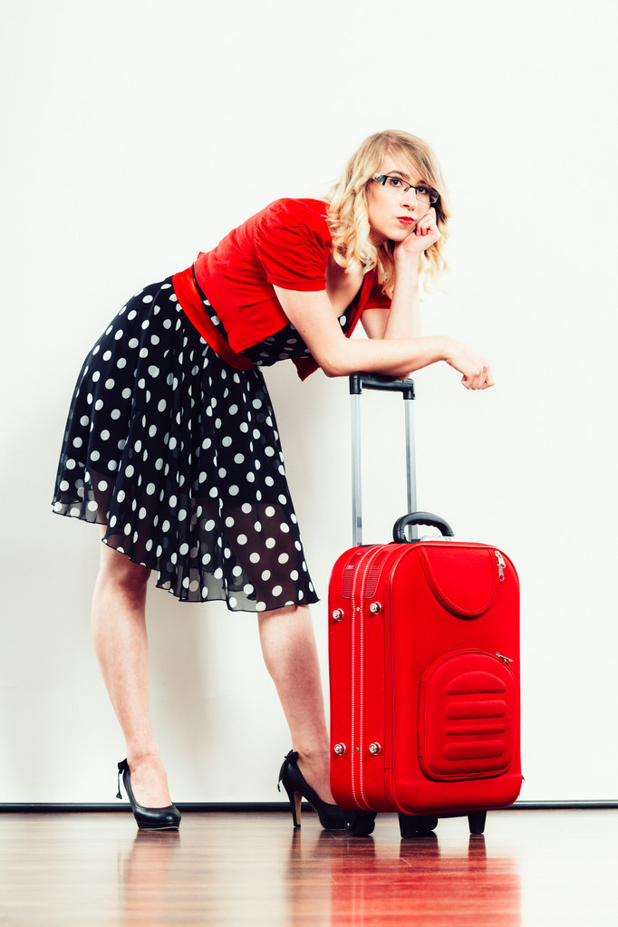 Elegante vrouw met rode koffer om na te denken over - Foto, afbeelding
