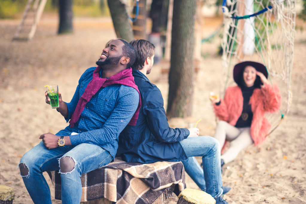 Lächelnde Freunde mit Cocktails beim Picknick - Foto, Bild