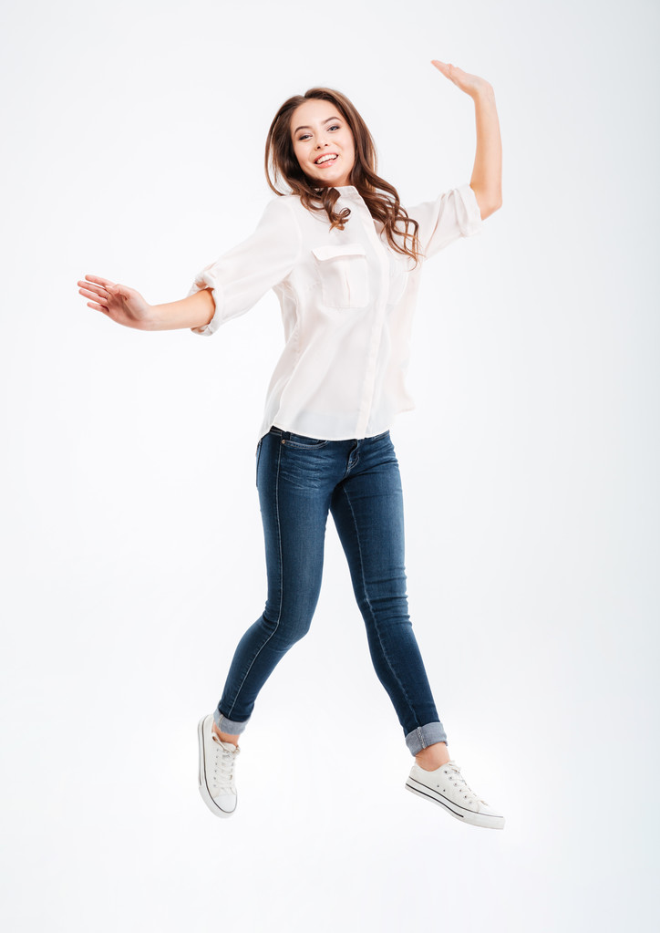 Volledige lengte portret van een lachende mooie vrouw springen - Foto, afbeelding