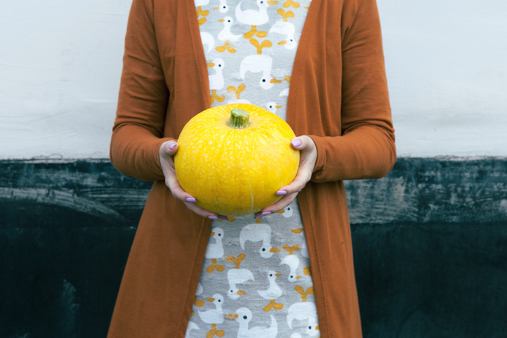 Frau hält gelben Kürbis in den Händen - Foto, Bild
