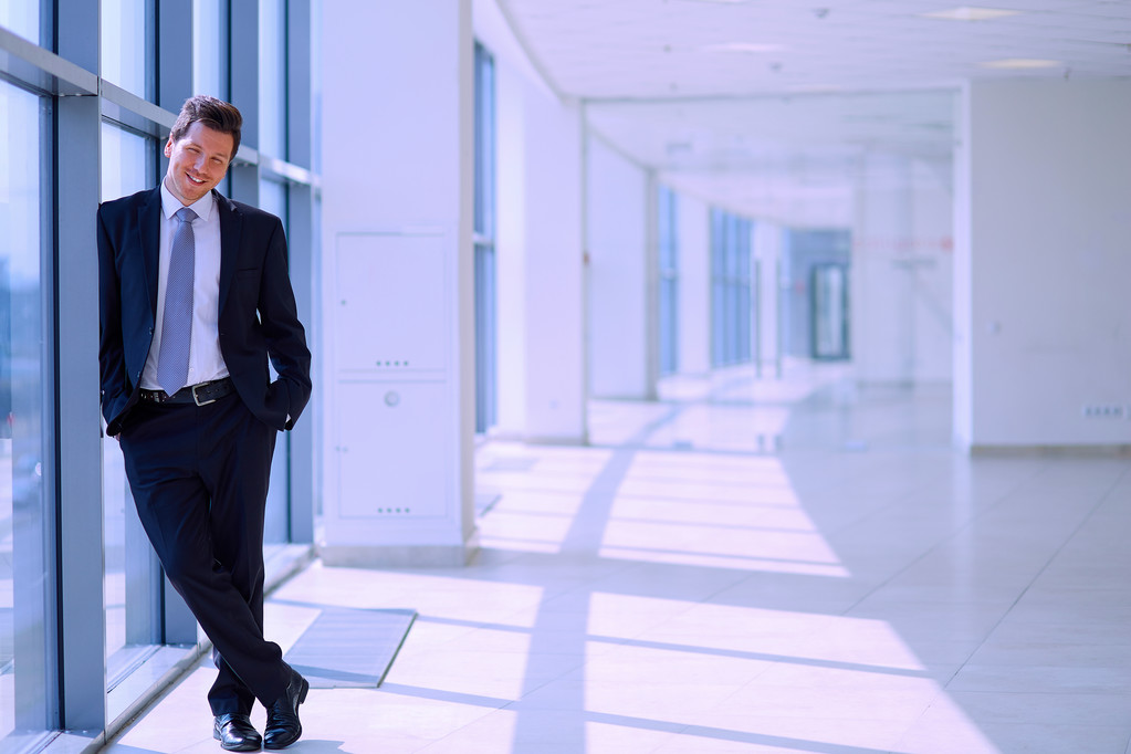 Empresário bem sucedido em pé no corredor sua empresa perto da janela
 - Foto, Imagem