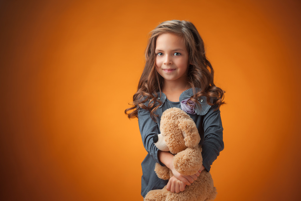 The cute cheerful little girl on orange background - Photo, Image