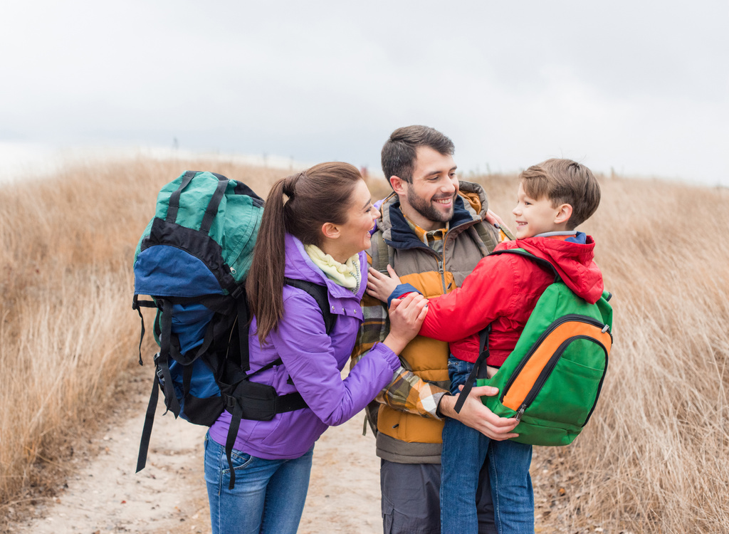 Happy family with backpacks hugging  - Photo, Image
