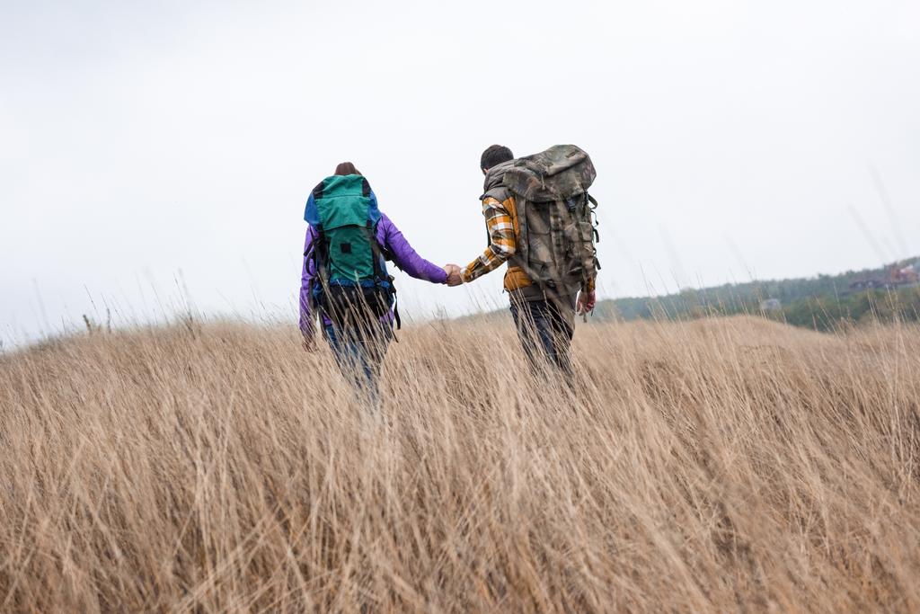 Молода пара з рюкзаками, що ходять у сільській місцевості
 - Фото, зображення