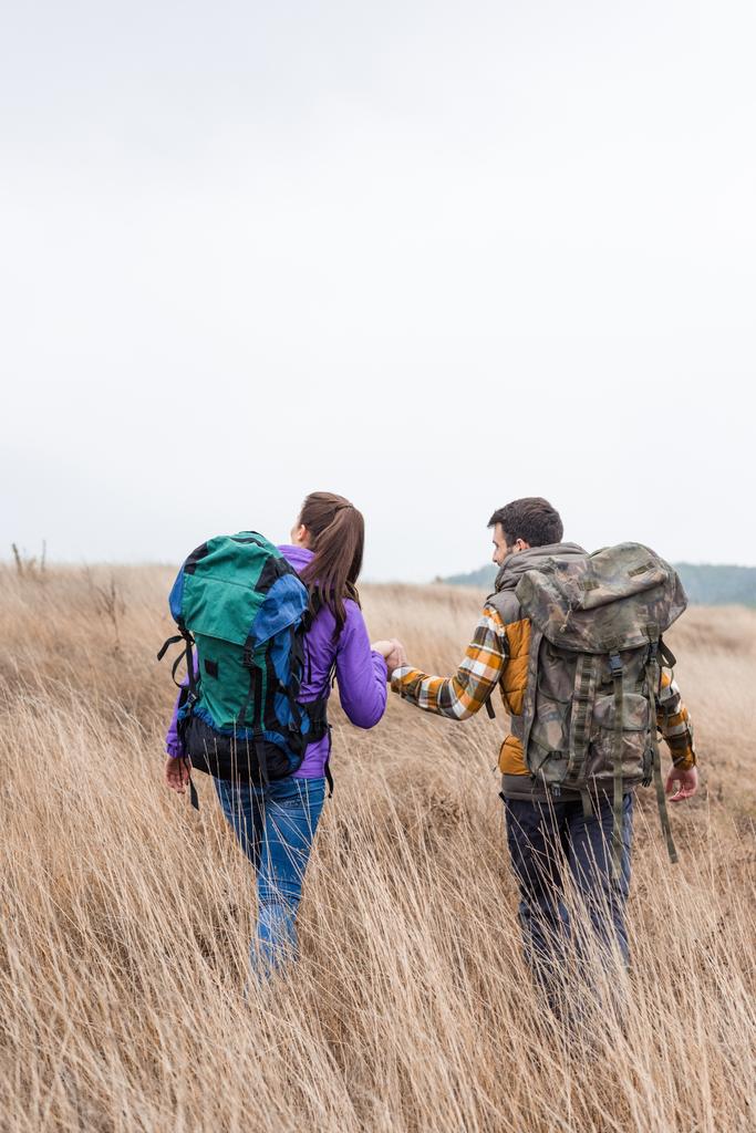 Young couple with backpacks walking in countryside - Photo, Image