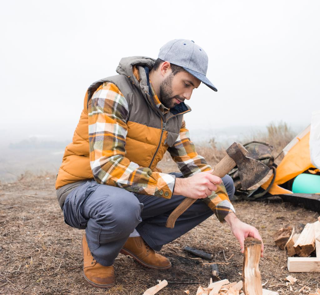 Mann hackt Brennholz mit Axt - Foto, Bild