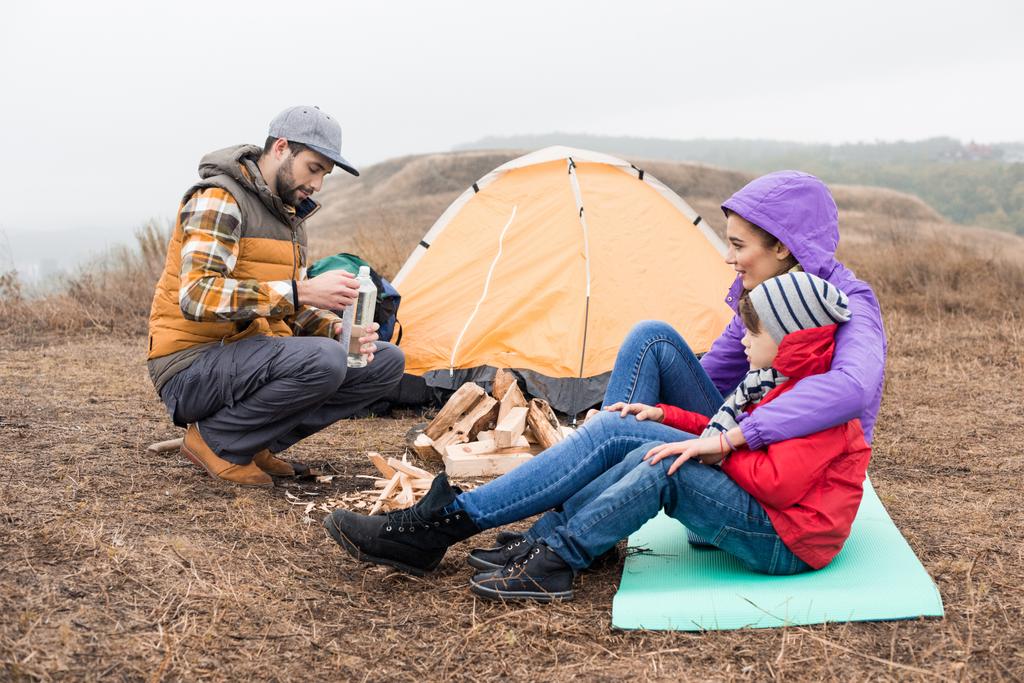 Happy young family sitting near tent - Fotografie, Obrázek
