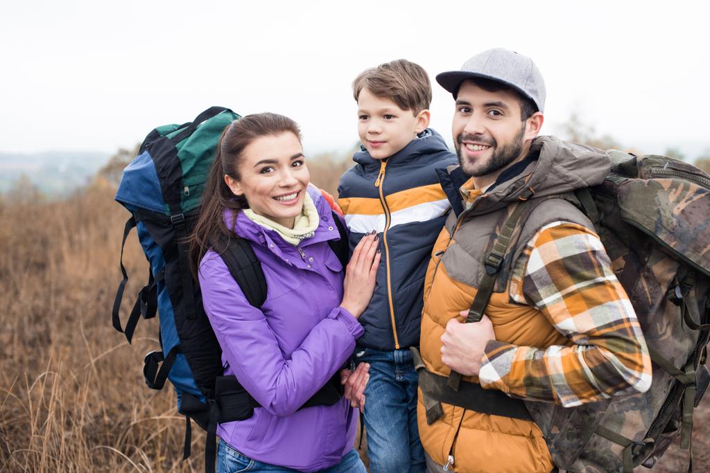 Smiling family with backpacks - 写真・画像