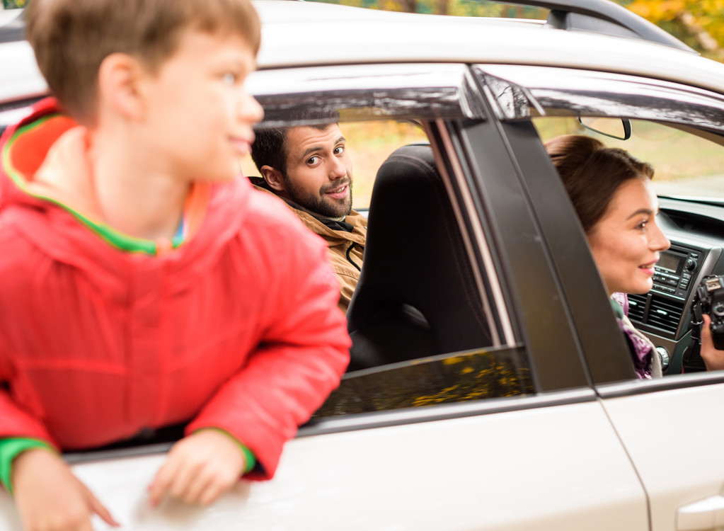 Улыбающийся мальчик смотрит в окно машины
 - Фото, изображение