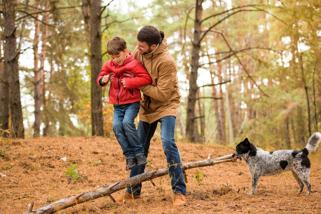 Garçon heureux jouant avec père et chien
  - Photo, image