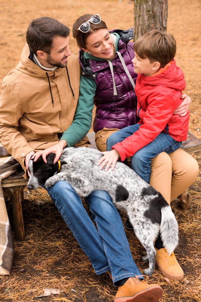 Feliz familia acariciando perro
 - Foto, Imagen