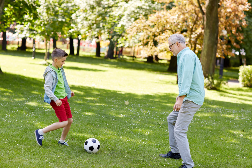 γέρος και αγόρι παίζει ποδόσφαιρο στο πάρκο καλοκαίρι - Φωτογραφία, εικόνα