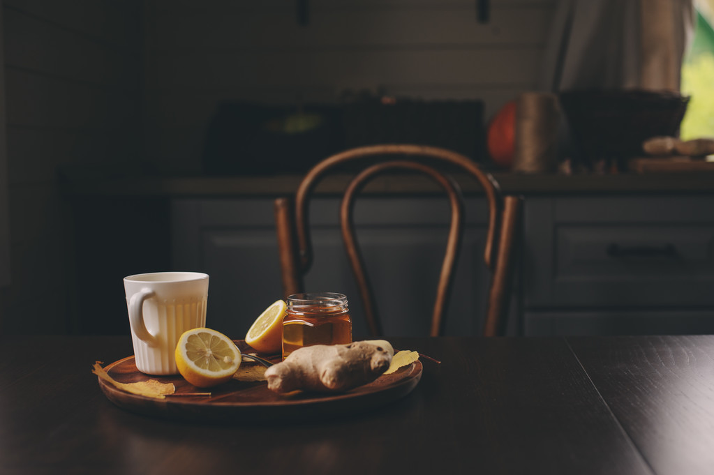 Kochen von Ingwer, Zitrone und Honig heißer Tee in dunklem rustikalem Interieur. Zutaten und Tasse auf Holzgrund - Foto, Bild