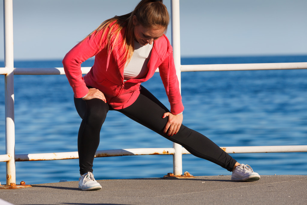 Женщина делает спортивные упражнения на открытом воздухе на море
 - Фото, изображение