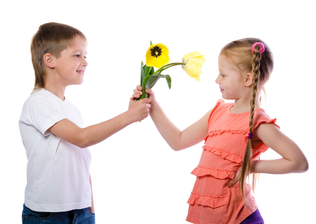 um menino dá uma menina tulipas amarelas no fundo branco
 - Foto, Imagem