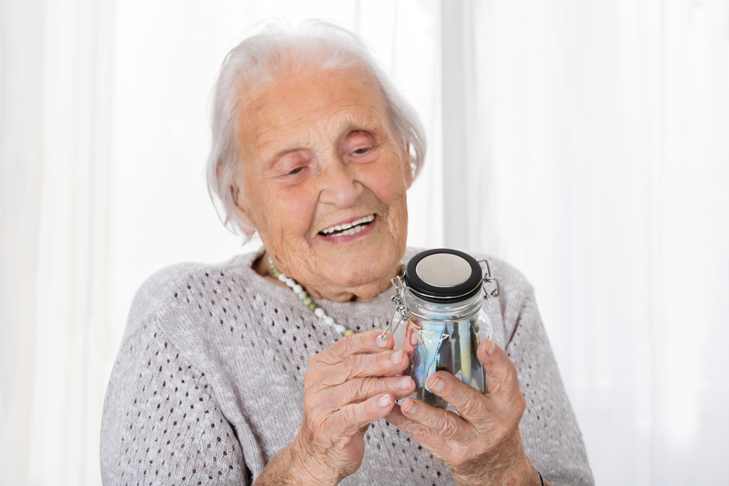 Femme âgée regardant pot d'argent
 - Photo, image