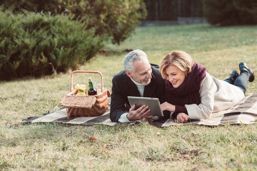 Couple souriant utilisant une tablette numérique
 - Photo, image