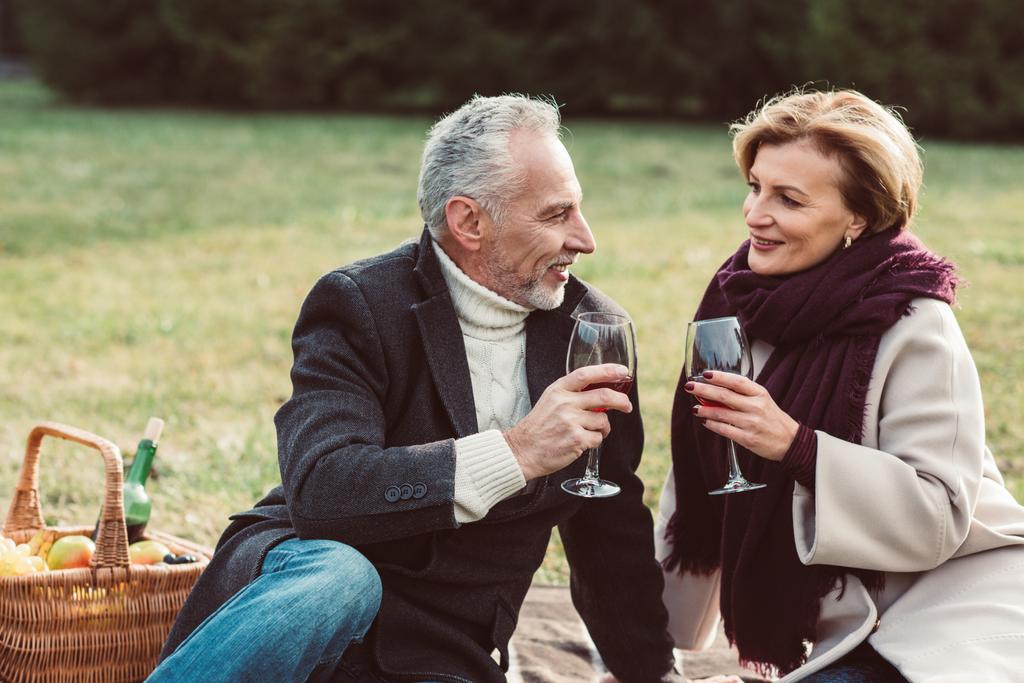Uśmiechający się para trzymając kieliszki do wina  - Zdjęcie, obraz