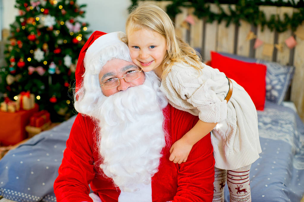 Santa Claus y linda chica preparándose para la Navidad
 - Foto, imagen