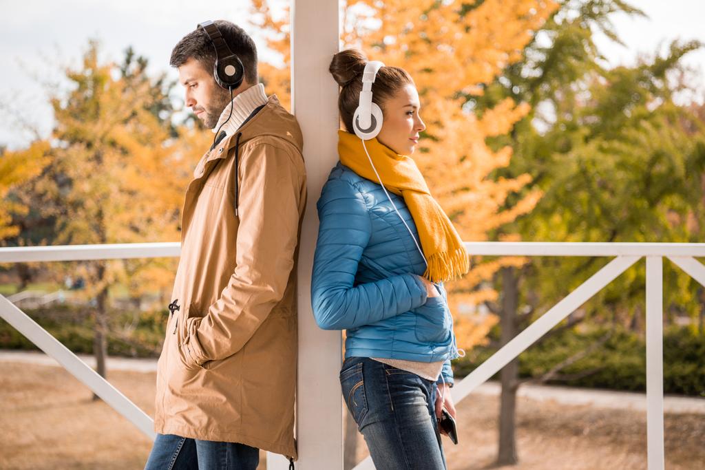 Mladý muž a žena stojící v sluchátka - Fotografie, Obrázek