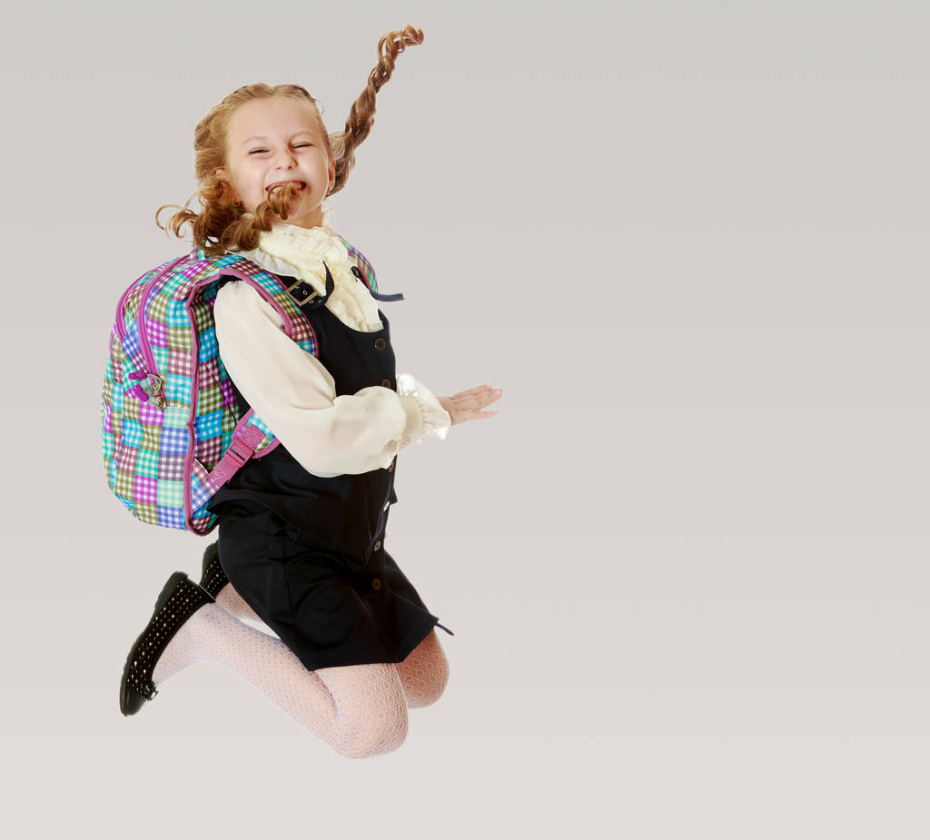 Dziewczyna uczennica z teczki za ramiona skacze - Zdjęcie, obraz