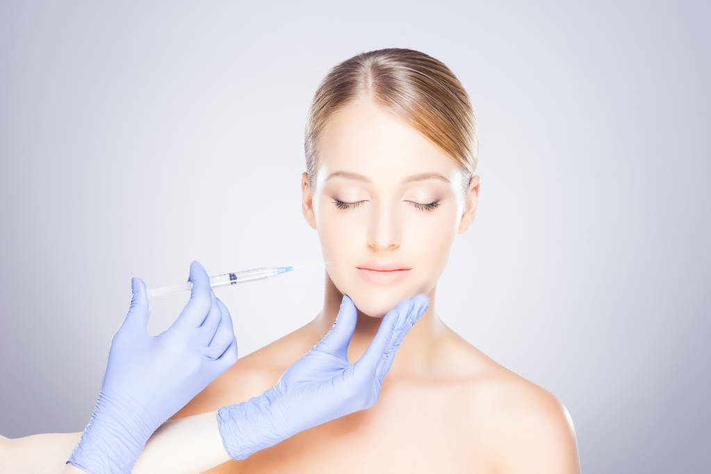 Médico haciendo inyección en la cara de la mujer
 - Foto, imagen