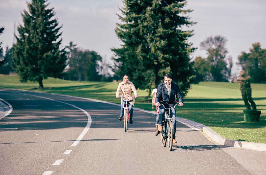 ευτυχισμένη οικογένεια ιππασία ποδήλατα στο πάρκο - Φωτογραφία, εικόνα