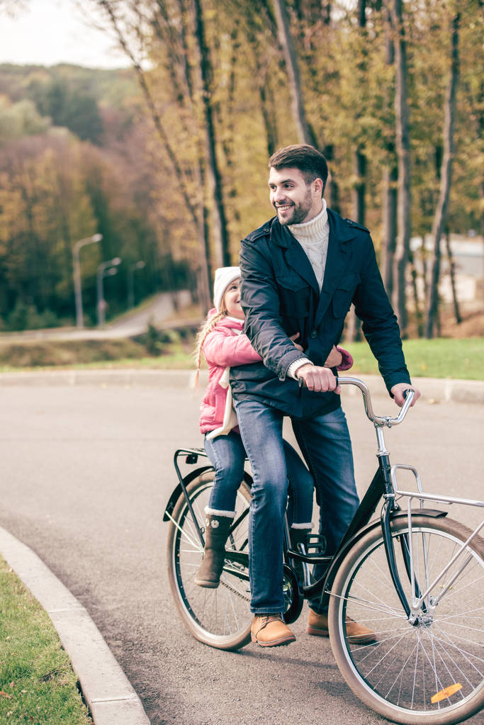 Vater trägt Tochter auf Fahrrad - Foto, Bild