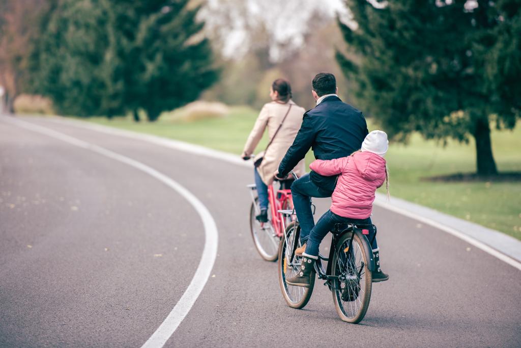 Bicicletas de equitação familiar no parque
 - Foto, Imagem