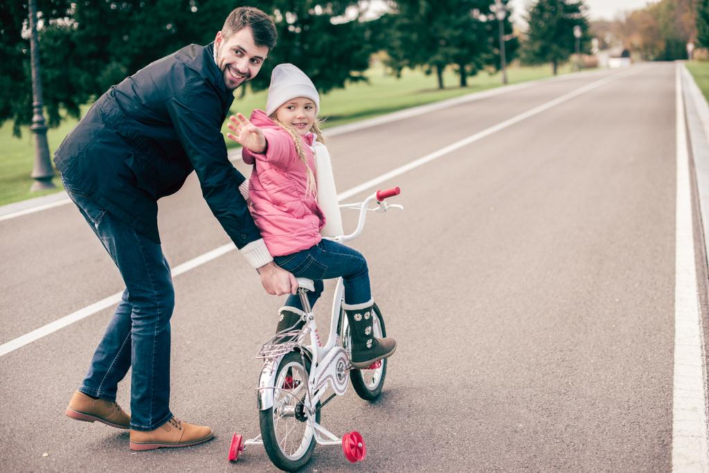 自転車に乗るように娘を教える父 - 写真・画像