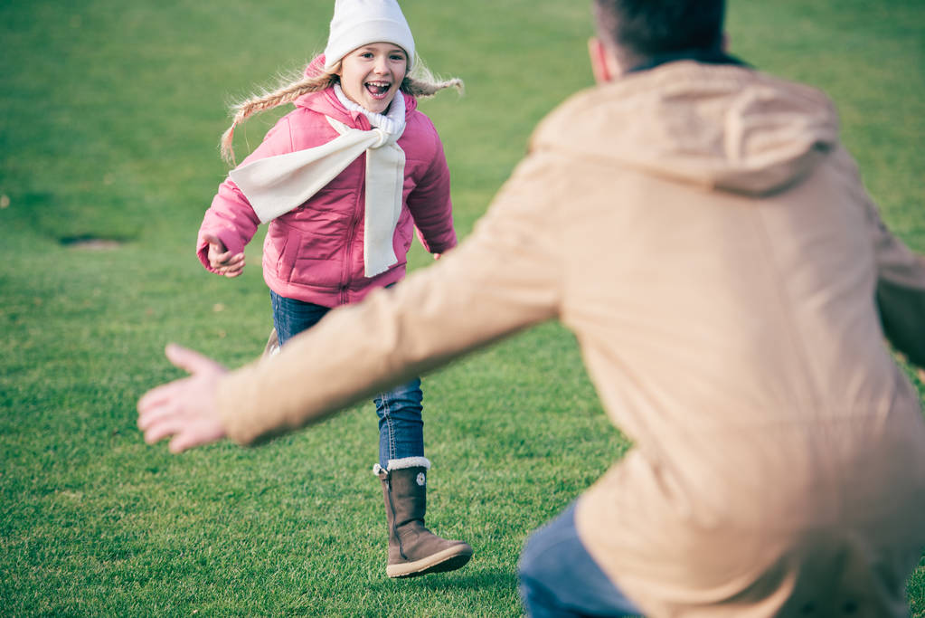 Suloinen hymyilevä tyttö juoksee isän luo
  - Valokuva, kuva