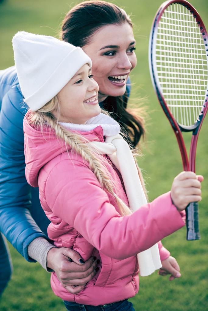 Uśmiechający się matka z córką, grać w badmintona - Zdjęcie, obraz