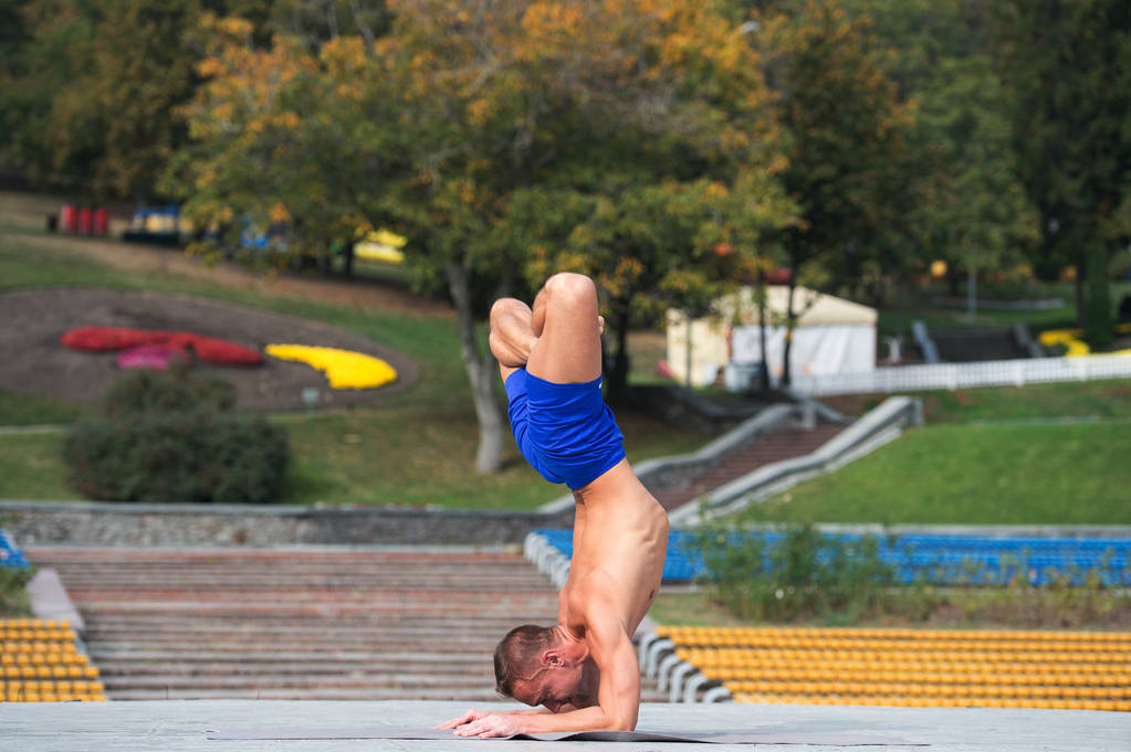 Atletický muž dělá jógu asanas v parku - Fotografie, Obrázek