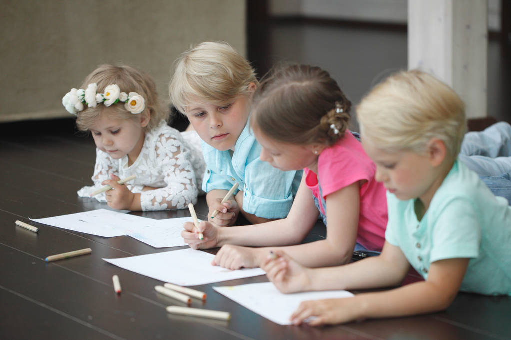 Группа милых детей рисует с красочными карандашами на полу - Фото, изображение