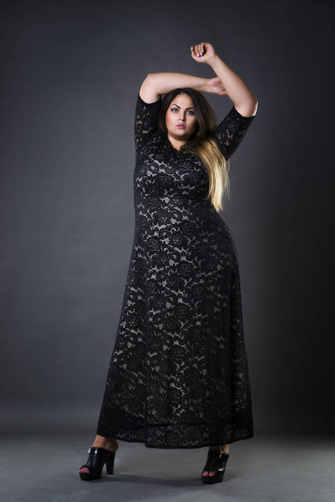 Giovane bella plus size modello in draghe nere, donna xxl su sfondo grigio studio
 - Foto, immagini