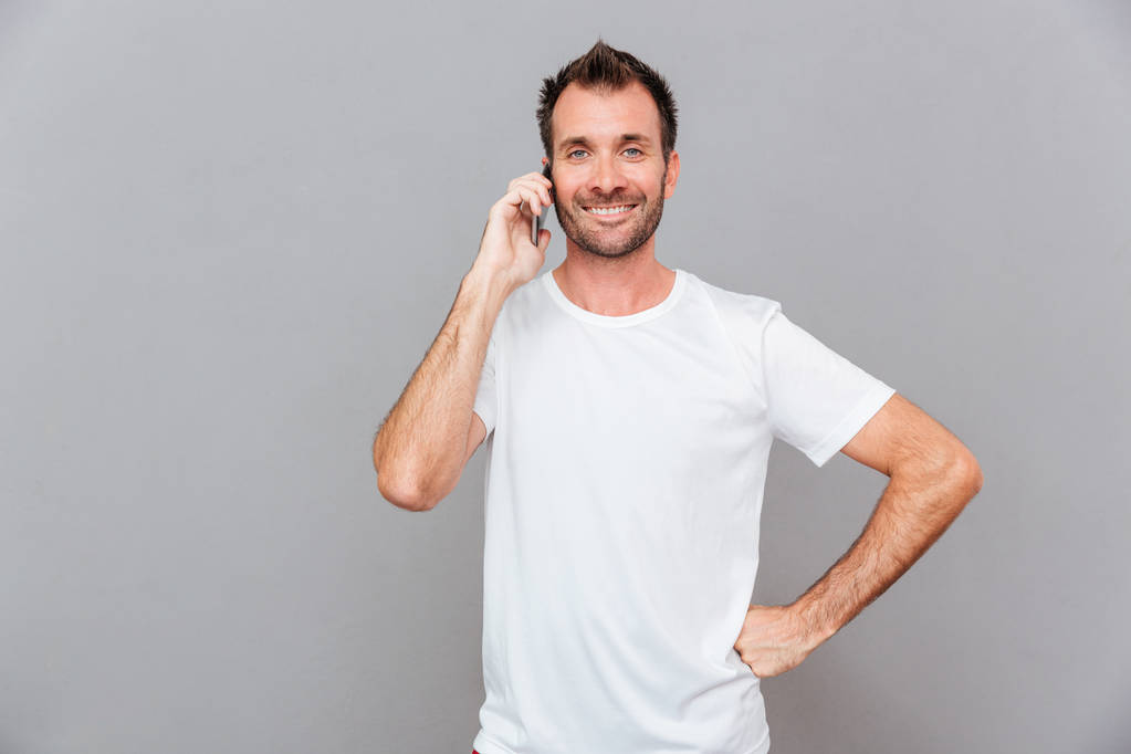 Usmívající se neformální muž mluví po telefonu - Fotografie, Obrázek